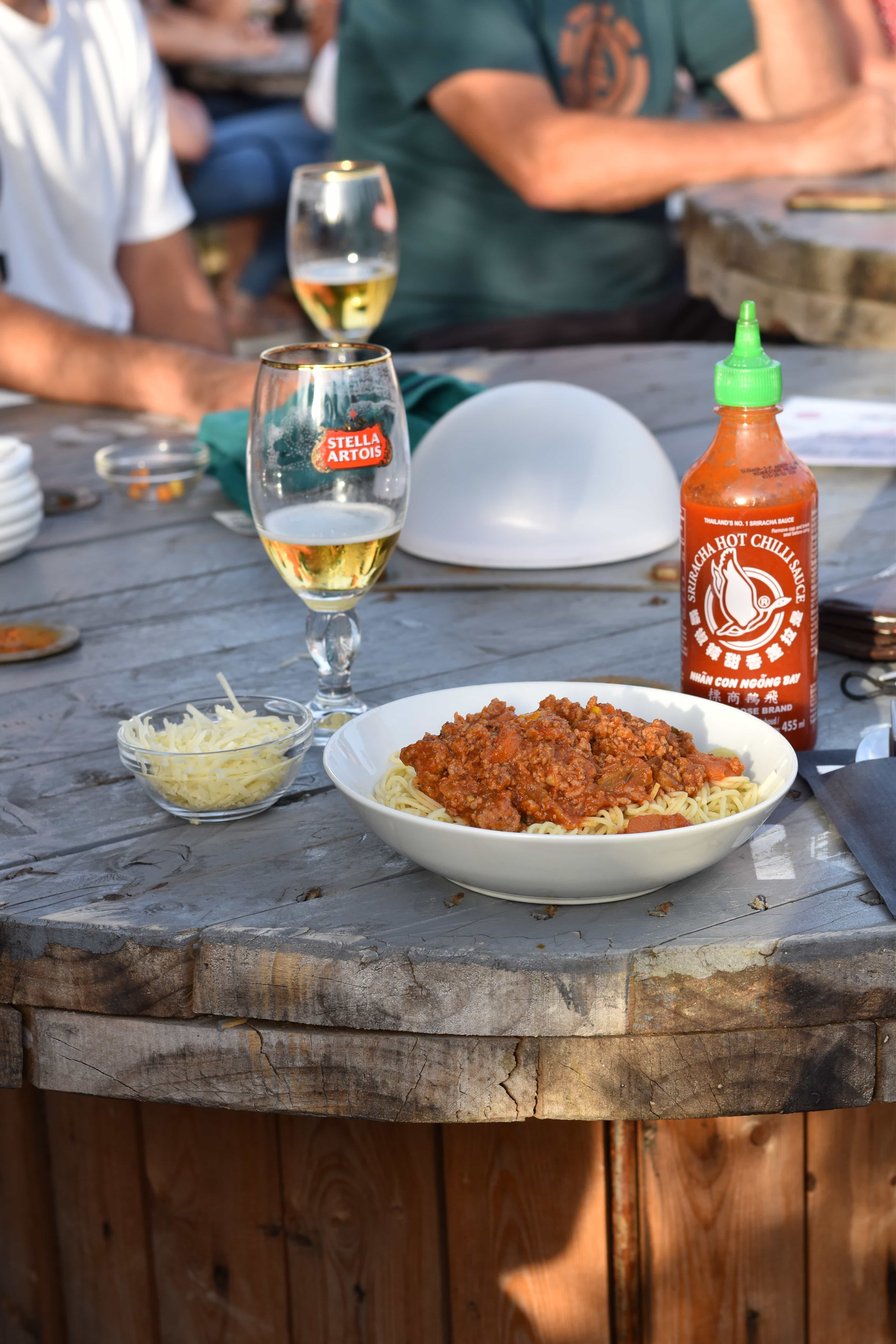 Spaghetti bolognese van de mamita bij café Den Bled Heffen, geserveerd op houten wijnvat